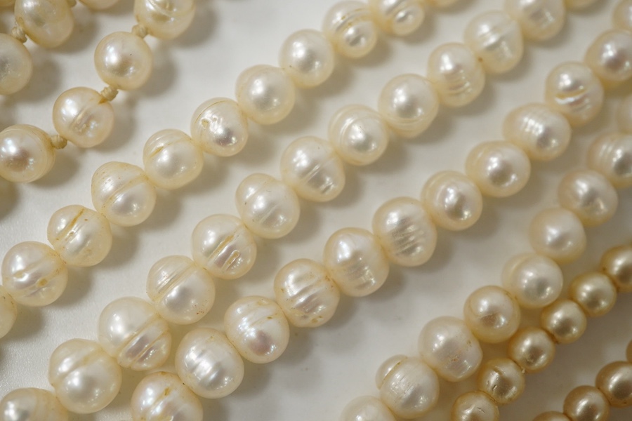 A collection of costume jewellery, comprising: a simulant pearl necklace with a green and colourless paste clasp; a fringe necklace set with circular-cut pastes; three strands of cultured pearls; a Royal Artillery cap ba